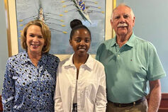 Scholarship recipient Melyse Ishimwe poses with Ilene and Rick Sheffer.